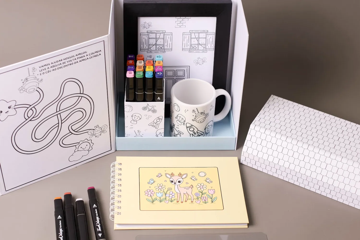 Kit completo da Casinha dos Artistas aberto sobre a mesa.